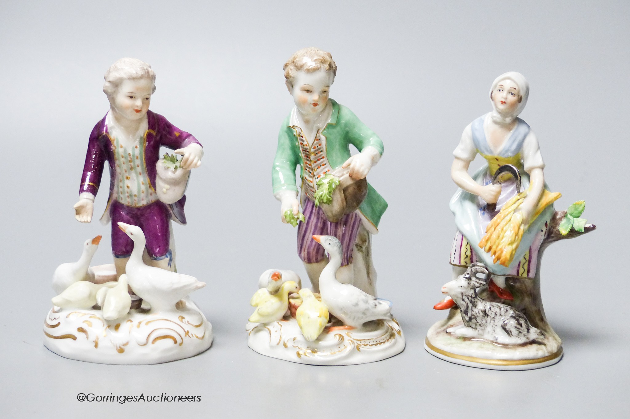 A Meissen porcelain group of a boy and ducks together with two Continental porcelain figures, tallest 12cm